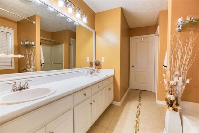 full bath with walk in shower, tile patterned flooring, a sink, and baseboards