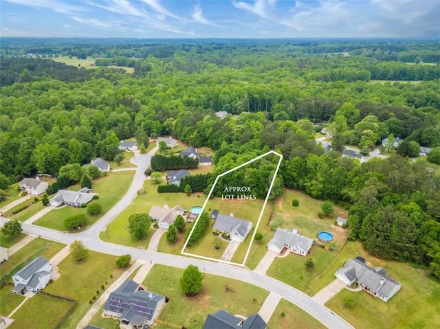 drone / aerial view featuring a residential view and a forest view