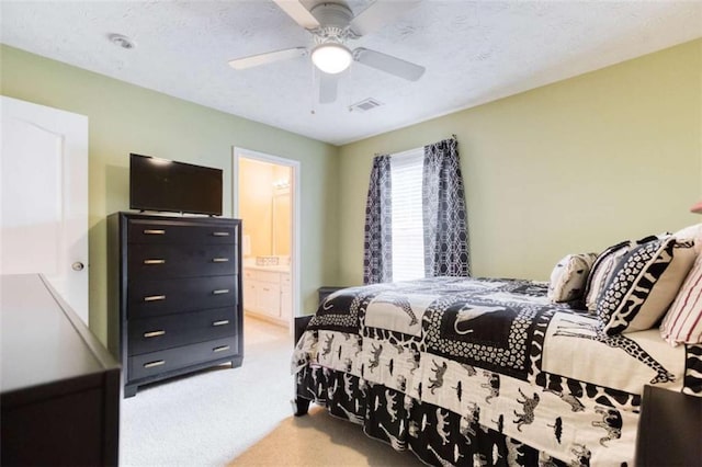 bedroom with a ceiling fan, carpet flooring, ensuite bath, and visible vents