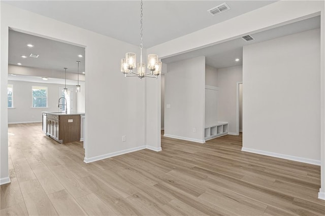unfurnished dining area with recessed lighting, baseboards, an inviting chandelier, visible vents, and light wood-style floors