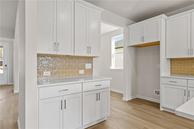 1682 Juniper Berry Way, Loganville, GA 30052 - kitchen featuring light countertops, white cabinets, healthy amount of natural light, and backsplash