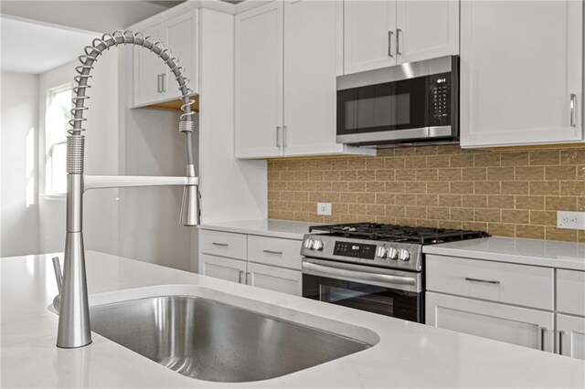 kitchen with light countertops, white cabinets, and appliances with stainless steel finishes