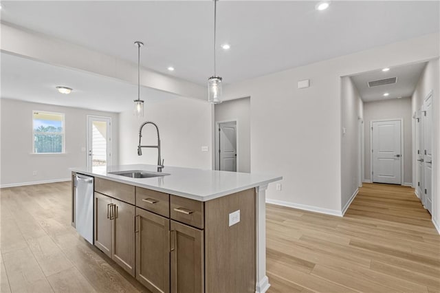 kitchen with stainless steel dishwasher, hanging light fixtures, light wood-style flooring, and a sink