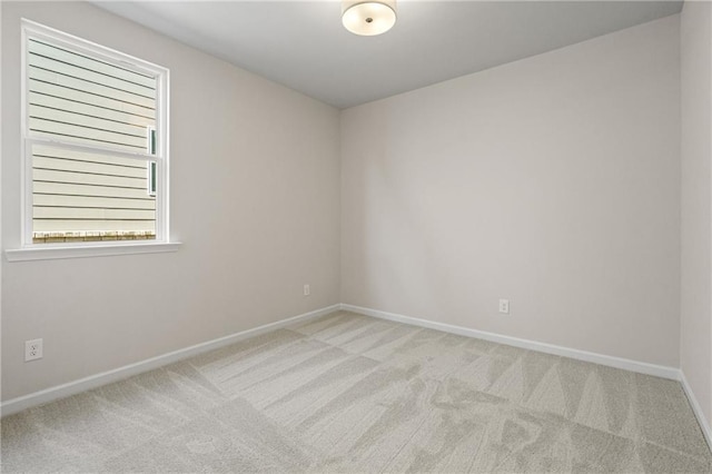 unfurnished room with light colored carpet, baseboards, and a healthy amount of sunlight