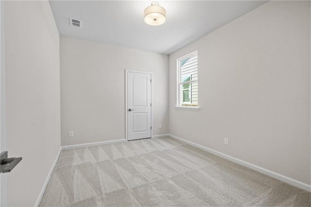 unfurnished room with visible vents, baseboards, and light carpet