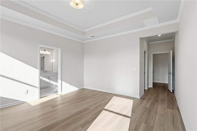 unfurnished room featuring baseboards, crown molding, visible vents, and wood finished floors