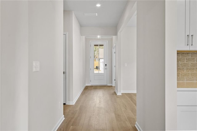 hall featuring light wood-style floors and baseboards