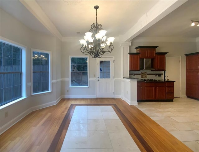 interior space with hanging light fixtures, light tile patterned floors, a chandelier, and backsplash