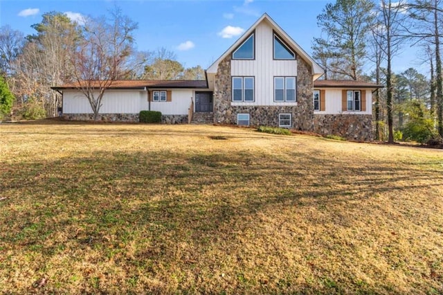 view of front of house with a front yard and stone siding