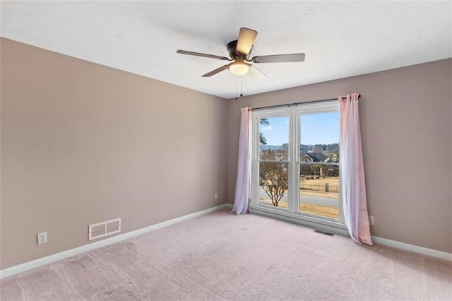 unfurnished room featuring carpet floors, visible vents, and baseboards