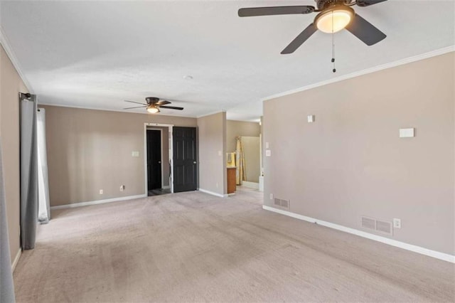 empty room featuring light colored carpet, visible vents, crown molding, and baseboards