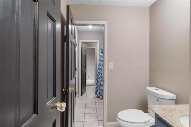 bathroom featuring a textured ceiling, vanity, toilet, and tile patterned floors