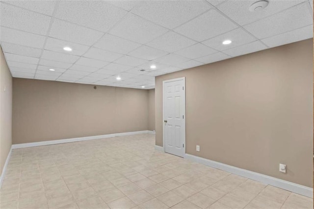 finished below grade area with a paneled ceiling, baseboards, and recessed lighting