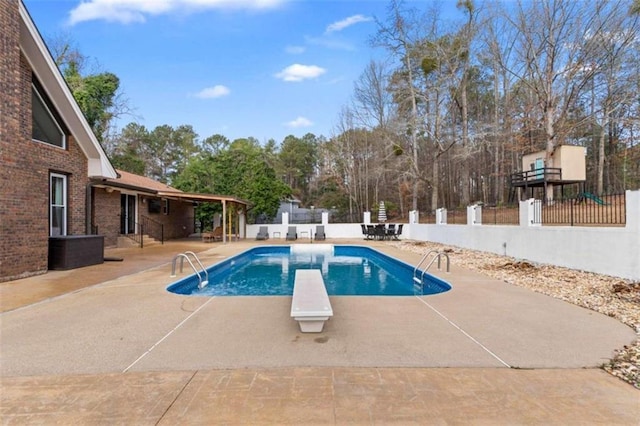 view of pool featuring fence private yard, a diving board, a fenced in pool, and a patio