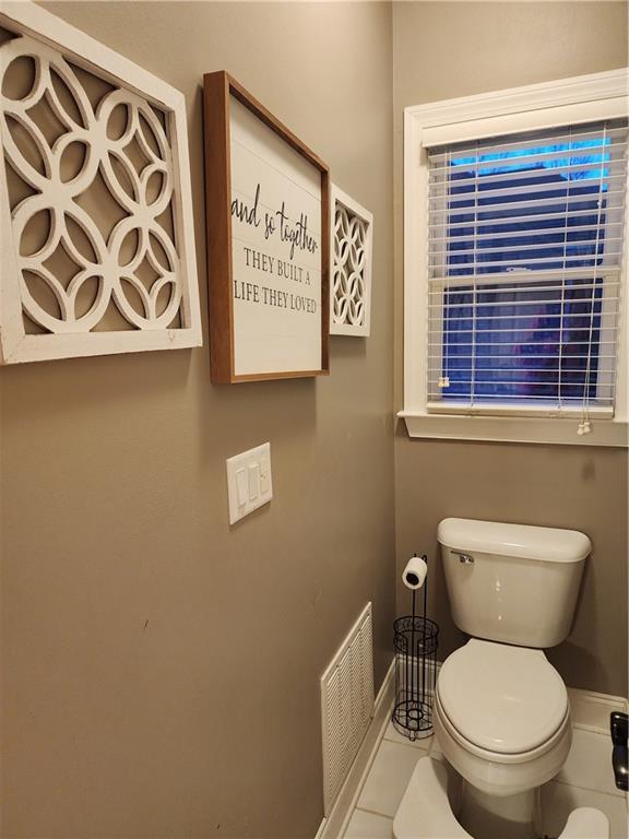 bathroom featuring toilet, visible vents, and tile patterned floors