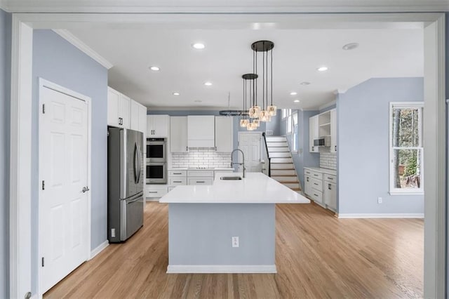 kitchen with sink, pendant lighting, stainless steel appliances, decorative backsplash, and white cabinets