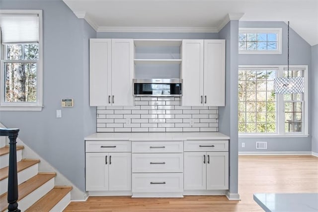 kitchen with hanging light fixtures, white cabinets, and decorative backsplash