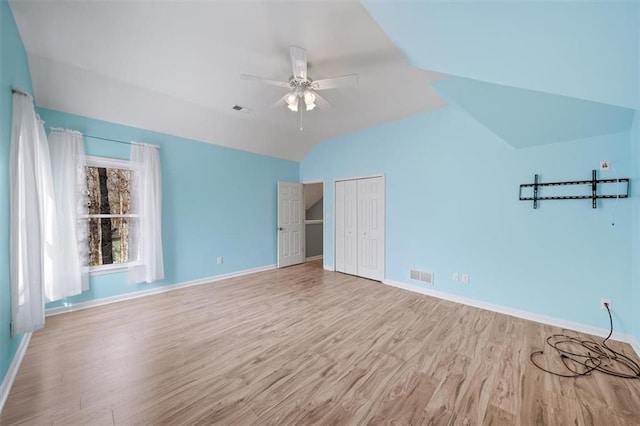 unfurnished bedroom with ceiling fan, lofted ceiling, light hardwood / wood-style floors, and a closet