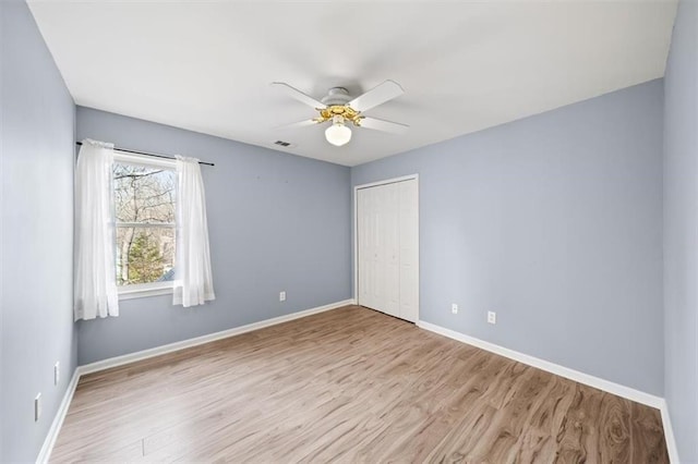 unfurnished bedroom with ceiling fan, light hardwood / wood-style floors, and a closet