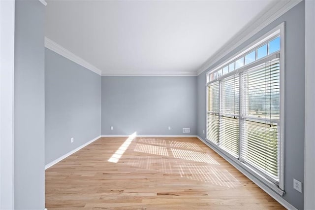 empty room with crown molding and light hardwood / wood-style flooring