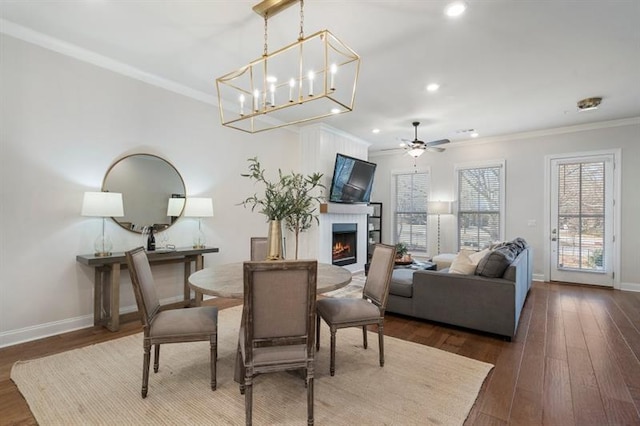 124 Everley Walk, Alpharetta, GA 30009 - dining area with crown molding, baseboards, a lit fireplace, dark wood finished floors, and ceiling fan
