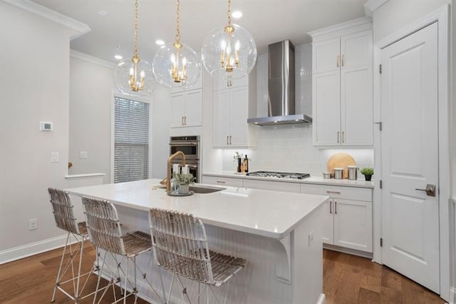 124 Everley Walk, Alpharetta, GA 30009 - kitchen featuring wall chimney exhaust hood, double oven, gas stovetop, a center island with sink, and white cabinets