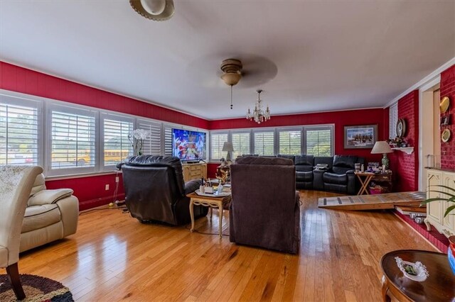 living room featuring light wood-type flooring, crown molding, and ceiling fan