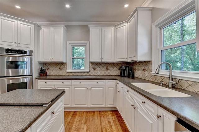 1595 Northcliff Trce, Roswell, GA 30076 - kitchen with double oven, a sink, white cabinets, light wood-style floors, and dark countertops