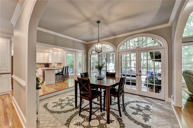 1595 Northcliff Trce, Roswell, GA 30076 - dining area with french doors, healthy amount of natural light, ornamental molding, arched walkways, and a chandelier
