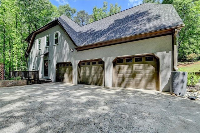 1595 Northcliff Trce, Roswell, GA 30076 - view of home's exterior featuring stucco siding, a shingled roof, and driveway