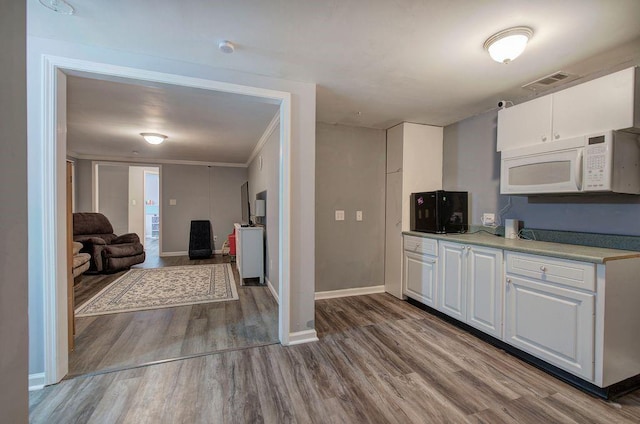 20 Friendship Rd, Euharlee, GA 30145 - kitchen featuring white microwave, wood finished floors, white cabinets, open floor plan, and light countertops