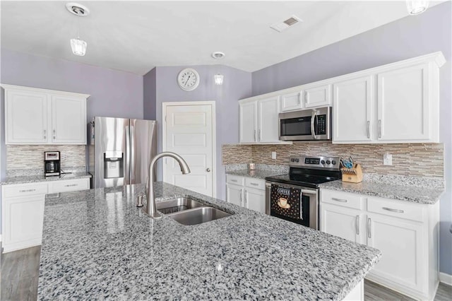 kitchen featuring white cabinetry, sink, light stone counters, stainless steel appliances, and a center island with sink