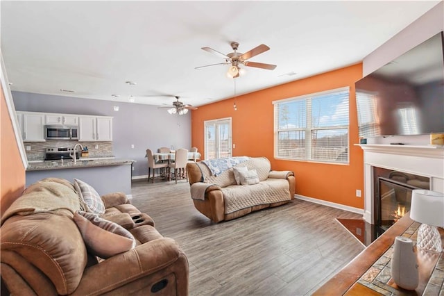 living room featuring ceiling fan, dark hardwood / wood-style flooring, and sink