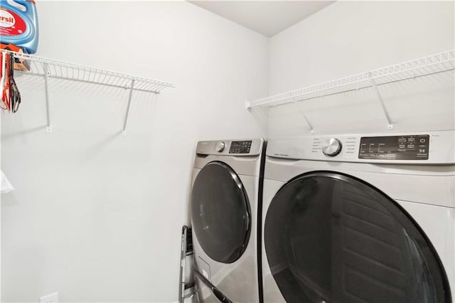 clothes washing area with washing machine and dryer