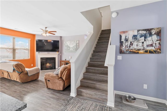 stairway featuring wood-type flooring and ceiling fan