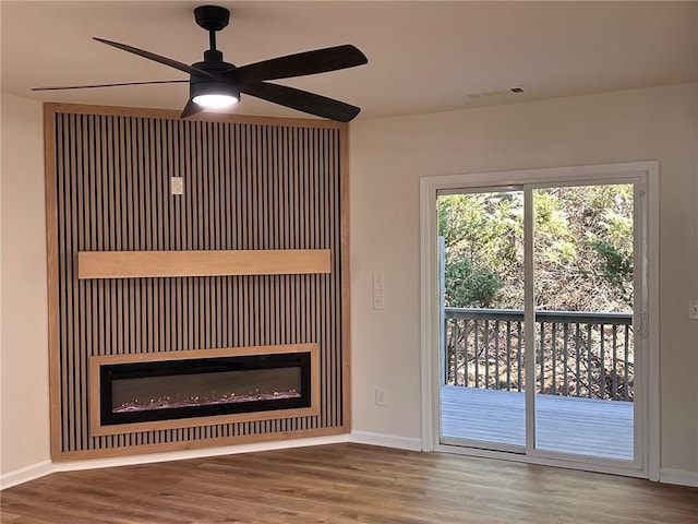 unfurnished living room featuring hardwood / wood-style flooring and ceiling fan