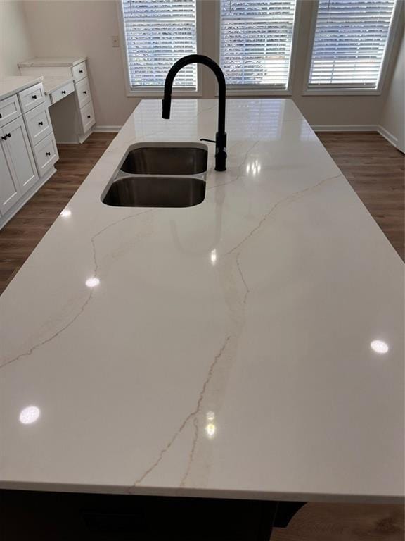 details featuring light stone counters, dark hardwood / wood-style flooring, sink, and white cabinets