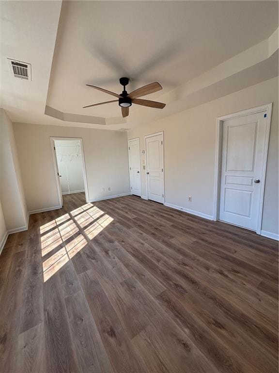 unfurnished bedroom with ceiling fan and dark hardwood / wood-style flooring