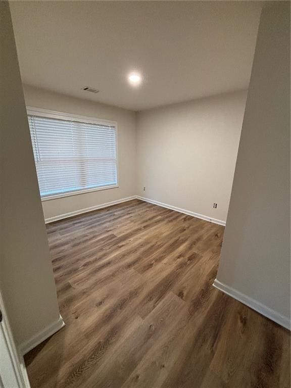 spare room with dark wood-type flooring