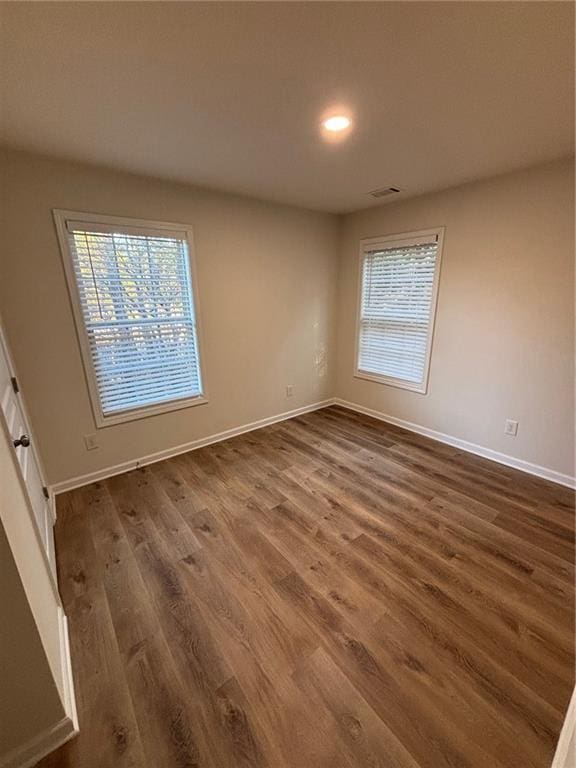 empty room with dark hardwood / wood-style flooring