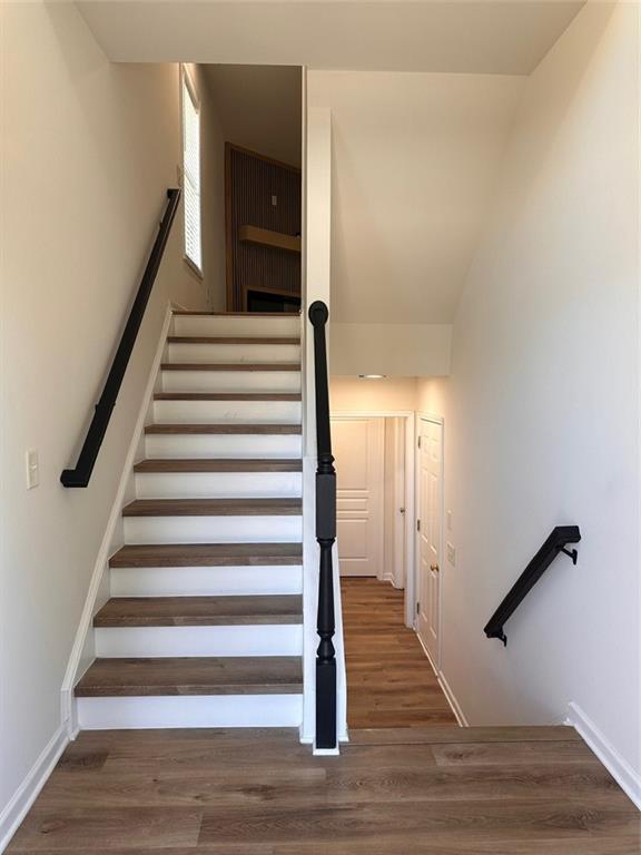 stairway with hardwood / wood-style floors