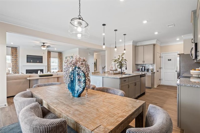 dining area with visible vents, ornamental molding, recessed lighting, light wood-style floors, and a fireplace