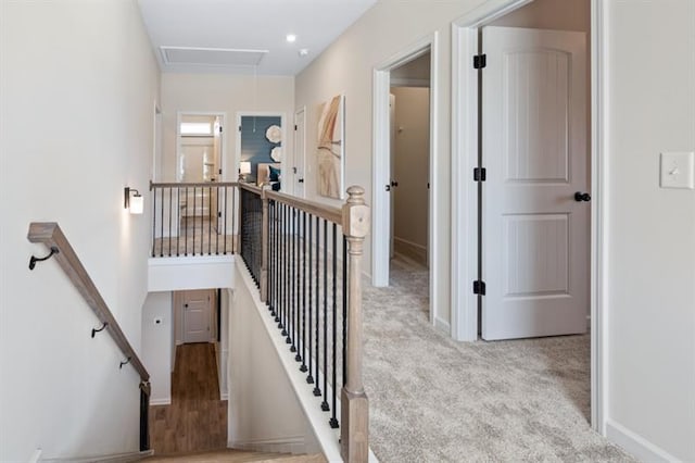 staircase featuring carpet flooring, attic access, and baseboards