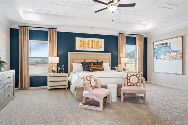 bedroom with carpet flooring, a raised ceiling, baseboards, and ornamental molding