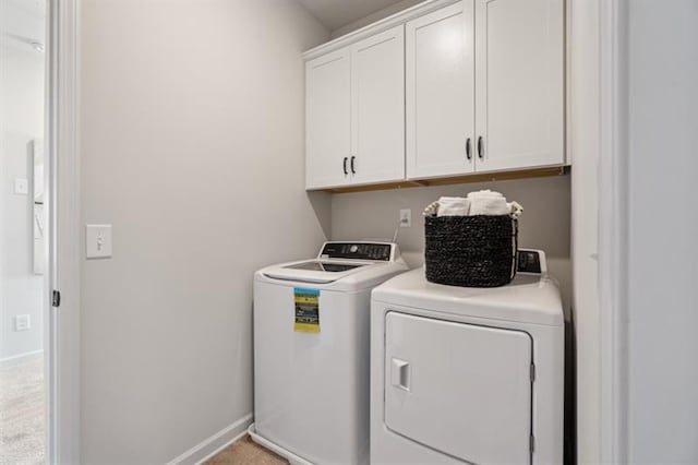 laundry room featuring cabinet space, baseboards, and washer and clothes dryer