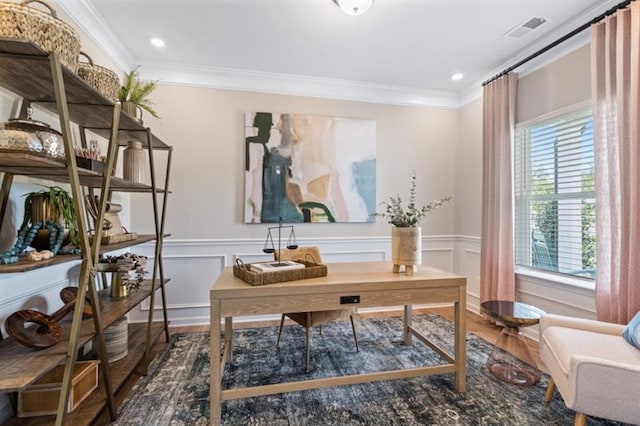 home office featuring visible vents, crown molding, a wainscoted wall, and wood finished floors