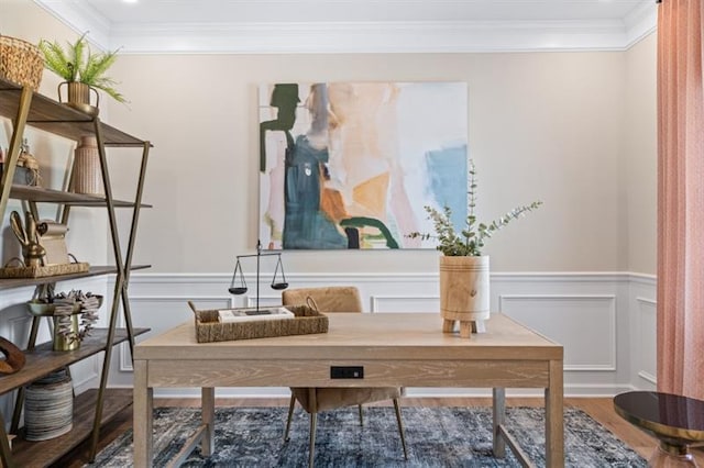 home office featuring a decorative wall, wainscoting, crown molding, and wood finished floors