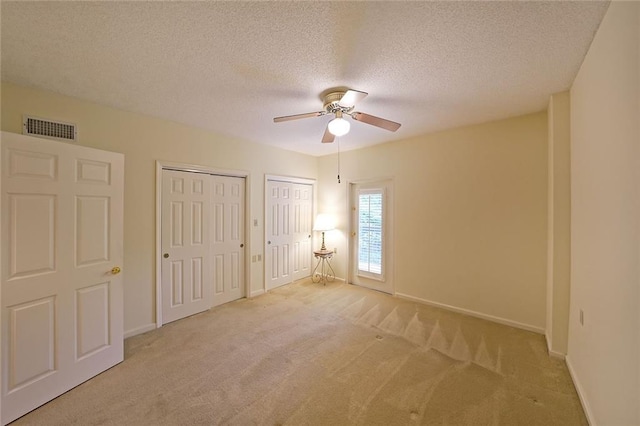 1800 Clairmont Lk Unit 213, Decatur, GA 30033 - unfurnished bedroom with multiple closets, carpet floors, a textured ceiling, and ceiling fan