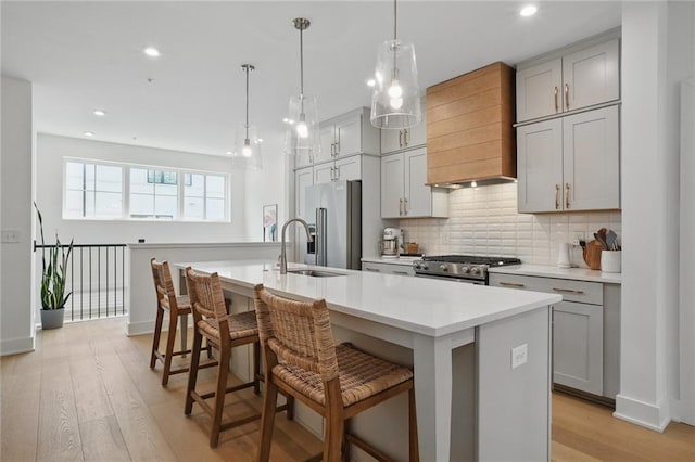 230 New St Unit 2102, Decatur, GA 30030 - kitchen with appliances with stainless steel finishes, a sink, premium range hood, backsplash, and a center island with sink