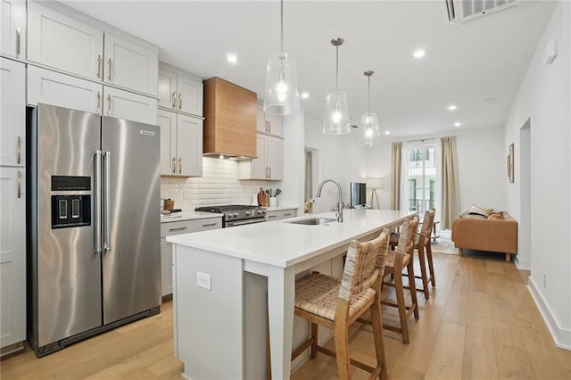 230 New St Unit 2102, Decatur, GA 30030 - kitchen with appliances with stainless steel finishes, a sink, light wood-type flooring, custom range hood, and tasteful backsplash